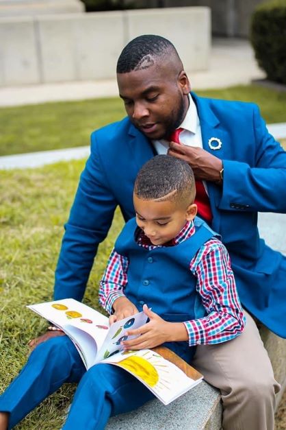Martinez and Harlem White (father and son) sitting together reading The Hungry Caterpillar.