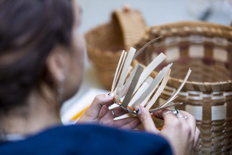 Basket weaving Over the shoulder photo of a woman weaving a basket from strips Black Ash.