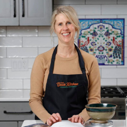 Nicole Bujewski Nicole Bujewski standing in a kitchen wearing an apron