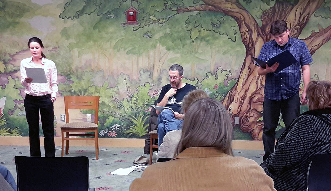 Actors perform in front of the Rosemary Garfoot Public Library tree mural