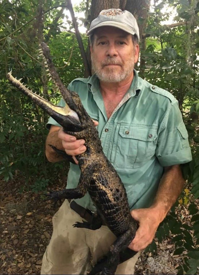 Bruce Shwedick holding a crocodile outdoors