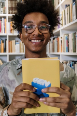 Photo of a young man holding a book with the words "Gen Z" on the cover